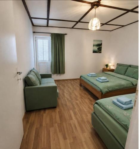a living room with two beds and a couch at Holiday Home Albina in Kustići