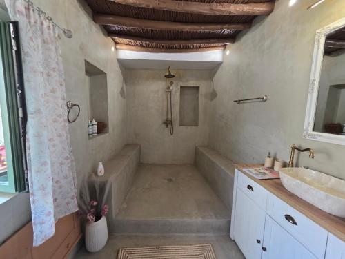 a bathroom with a tub and a sink at Floura's Kamariko - Authentic Rhodian Village House in Archangelos