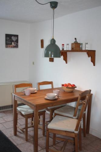 a wooden table with chairs and a bowl of fruit on it at Kleine Auszeit Blumenthal in Ferdinandshof