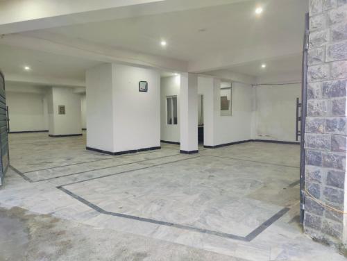 an empty room with white walls and a brick wall at Snow Stones in Khaira Gali