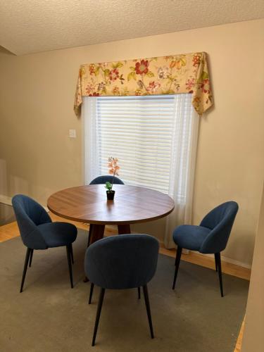 a dining room with a table and chairs and a window at Modern Basement Suit west side with Room 4 in Edmonton