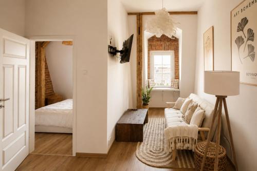 a living room with a couch and a bed at Jainty Apartments Bytom in Bytom