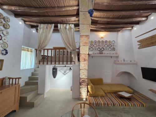 a living room with a couch and a staircase at Floura's Kamariko - Authentic Rhodian Village House in Archangelos