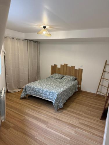 a bedroom with a bed and a ladder in it at Le Grimpeur in Achères-la-Forêt