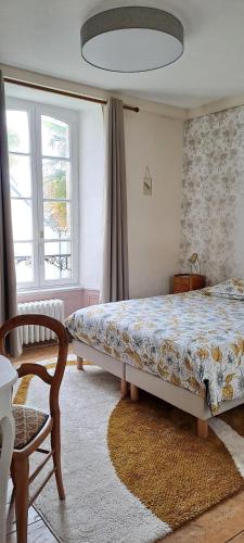 a bedroom with a bed and a chair and a window at Ty Palms - Maison d'hôtes in Plomodiern