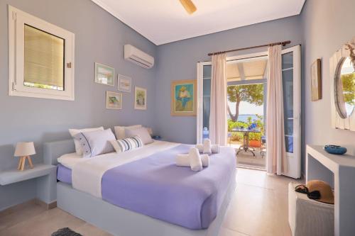a bedroom with two beds and a large window at Villa Irini in Porto Heli
