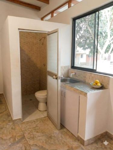 a bathroom with a toilet and a sink and a window at Casa Hospedaje en Tarapoto in Tarapoto