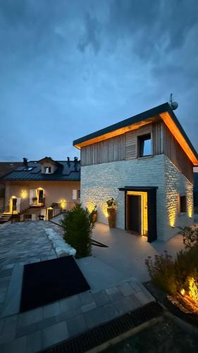 a brick house with a courtyard at night at Maso K La Mucca Rossa in Folgaria