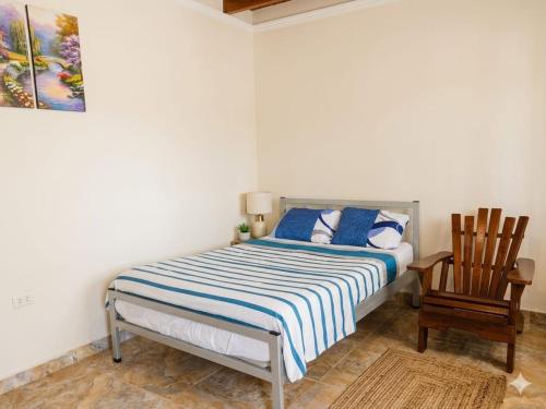 a bedroom with a bed and a wooden chair at Casa Hospedaje en Tarapoto in Tarapoto