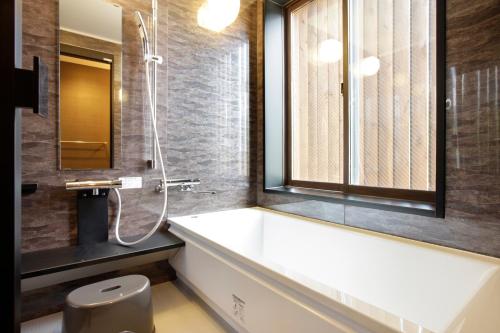a bathroom with a tub and a shower and a toilet at Royal Hotel Kawaguchiko in Fujikawaguchiko