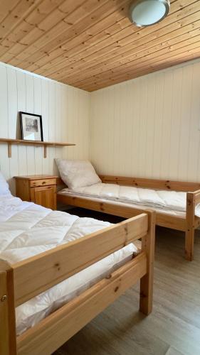 a room with two beds in a room with wooden ceilings at Salt&Stone in Gryllefjord