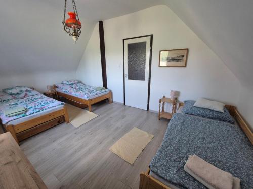 a room with two beds in a room with a staircase at Varjas apartman in Ábrahámhegy