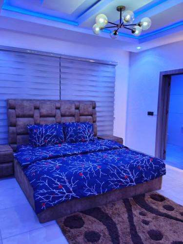 a bedroom with a bed with blue sheets and a ceiling at Apartments 4B Block B in Lagos
