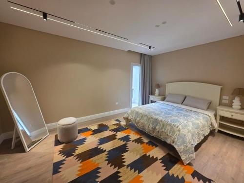 a bedroom with a bed and a rug at Boho Chic 2BR Retreat Mountain View Executive in New cairo