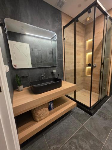 a bathroom with a sink and a glass shower at Boho Chic 2BR Retreat Mountain View Executive in New cairo