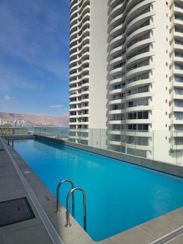 a swimming pool on the roof of a building with two tall buildings at PENINSULA DE CAVANCHA, Vista ESPECTACULAR in Iquique