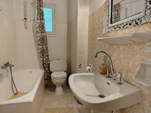 a bathroom with a sink and a tub and a toilet at Vanilla House Paleokastritsa in Paleokastritsa