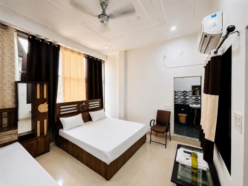 a bedroom with a bed and a chair in a room at Radha Krishna Hotel in Karauli
