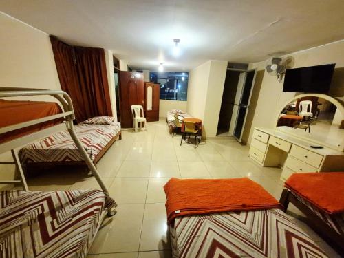 a room with three bunk beds and a desk at Hospedaje Valencia in Ica