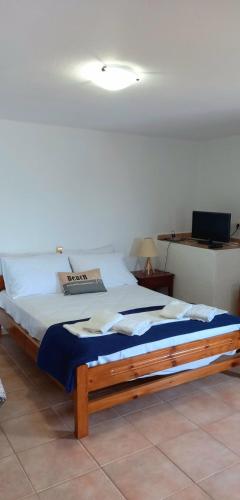 a bedroom with a large bed with a blue blanket at Ra's Seacastle in Tsoutsouros
