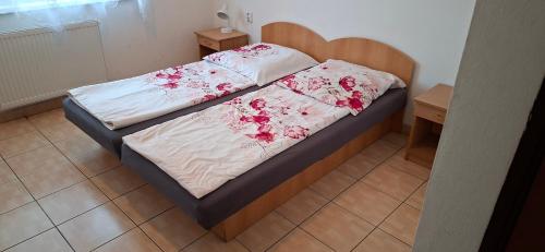 a bedroom with a bed with a wooden headboard at PENZION EUROPA Diakovce in Diakovce