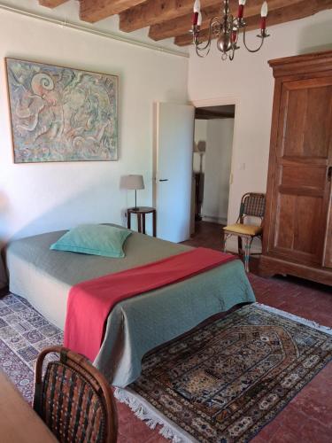 a bedroom with a bed with a red and green blanket at Gîte Le Tremblay in Thianges