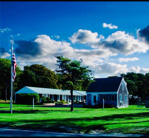 a blue house with a flag in front of it at The Chatham Motel in Chatham