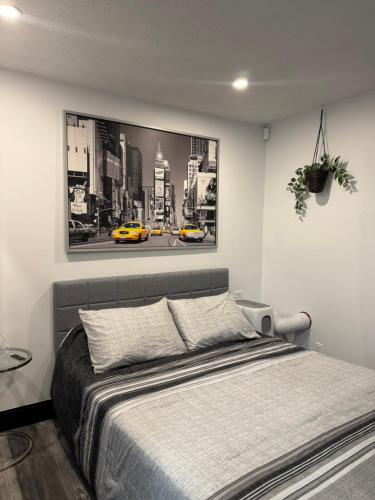 a bedroom with a bed and a picture of a city at Studio Moderne Chic Gatineau Ottawa in Gatineau