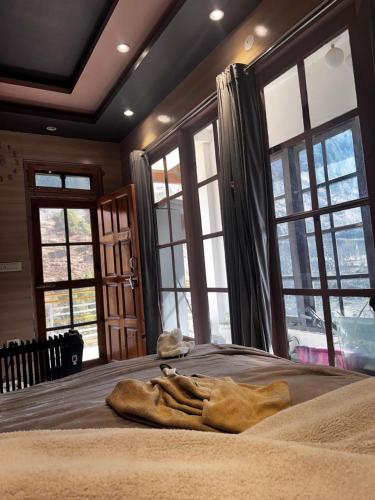 a bedroom with a large bed with large windows at kingsgate in Nerul