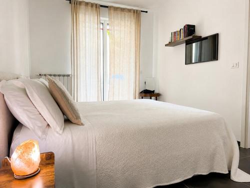 a bedroom with a white bed with a window at Gate 10 - Bari Airport Apartment in Bari
