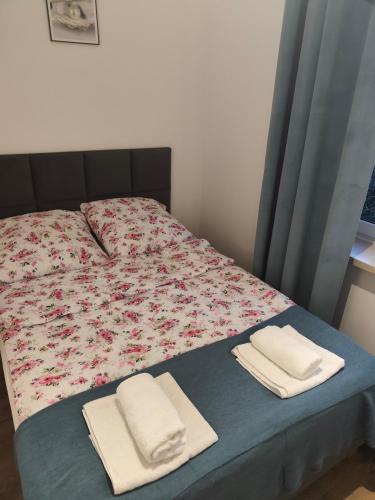 a bed with two towels on top of it at Apartamenty Raszyn in Raszyn