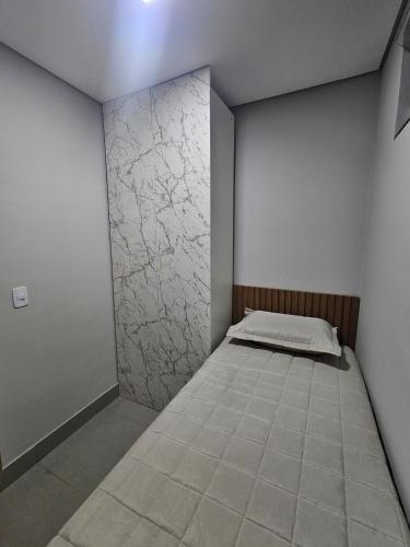 a bedroom with a bed in a room with a wall at D Castro Executive in Montes Claros