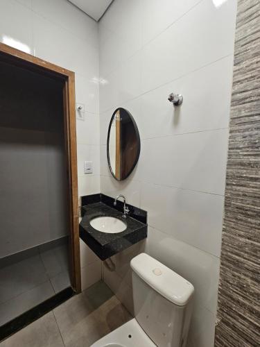a bathroom with a white toilet and a mirror at D Castro Executive in Montes Claros