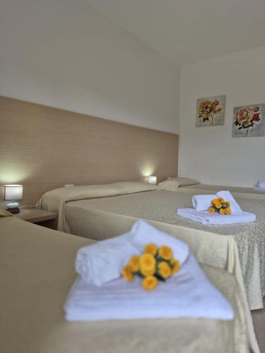 a hotel room with two beds with flowers on them at Albergo Athena Mare in Sibari
