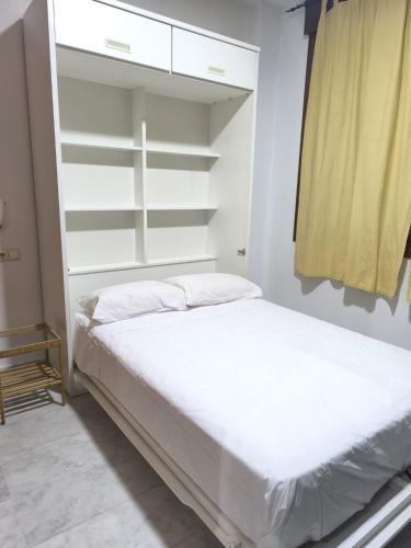 a bedroom with a white bed and white shelves at Lux Sevilla Elegance in Seville