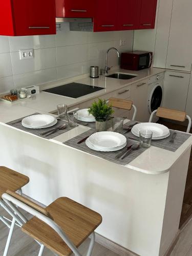 a kitchen with red cabinets and white plates on a counter at Casa Aliseda in Béjar