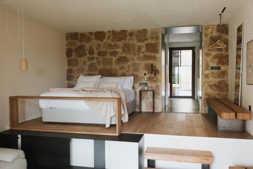 a bedroom with a bed and a stone wall at Los ojos del Alai in Labastida