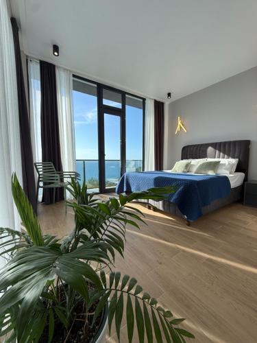 a bedroom with a bed and a large window at Modern Villa - infinity pool & Panoramic Sea View in Kvariati