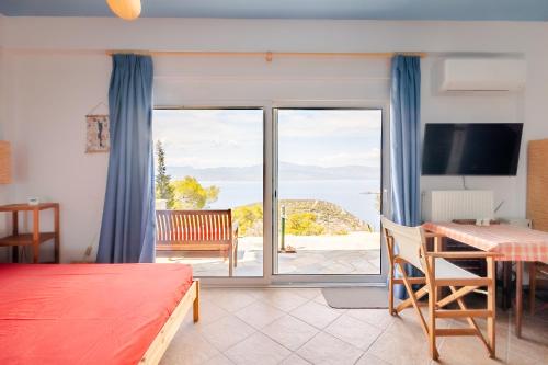a bedroom with a bed and a table and a balcony at Fragola in Pefkali