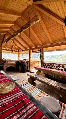 a room with tables and rugs in a building with wooden ceilings at La Tarani in Vatra Dornei