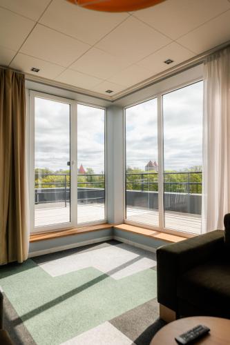 ein Wohnzimmer mit großen Fenstern und einem Sofa in der Unterkunft Meri Seaside Hotel & SPA in Kuressaare