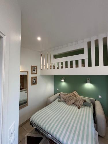 a bedroom with a bed with a green wall at Le Nid d'escale in Tillé