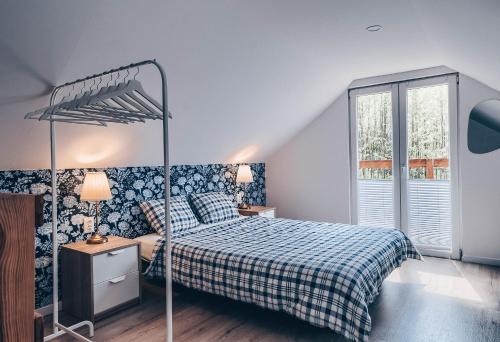 a bedroom with a bed with a blue and white blanket at JEZIORAKI Uroczy domek i sauna 400m od jeziora Nowa Jedlanka in Jedlanka Nowa