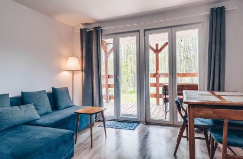 a living room with a blue couch and a table at JEZIORAKI Uroczy domek i sauna 400m od jeziora Nowa Jedlanka in Jedlanka Nowa
