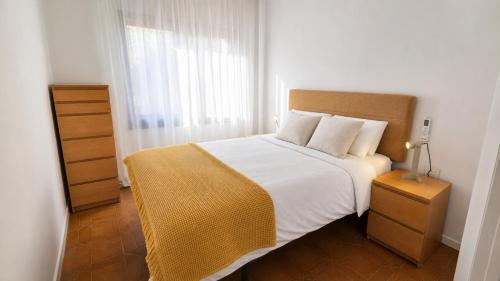 a bedroom with a large white bed with a window at La Sènia in Miravet