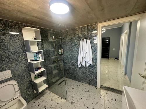 a bathroom with a shower and a toilet and a sink at Prive Home in Maliq