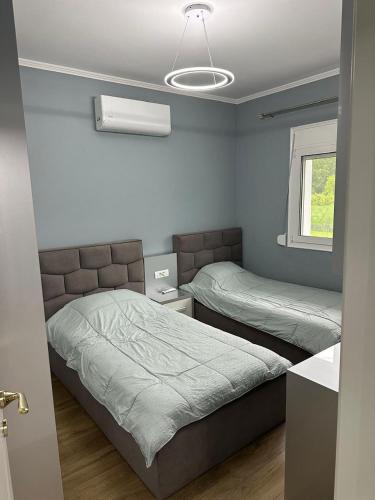 a bedroom with two beds and a window at Prive Home in Maliq