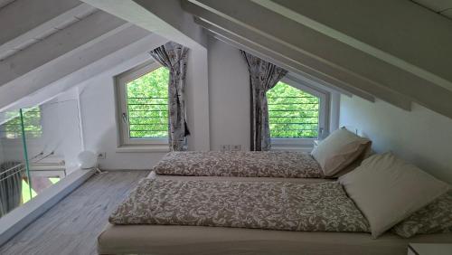 two beds in a room with two windows at Ledro Nest in Ledro