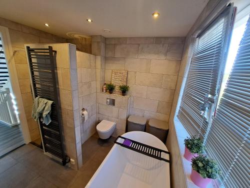 a small bathroom with a toilet and a tub at Villa shared Fieldsight Doornspijk - a shared villa no breakfast in Doornspijk