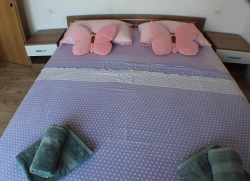a bed with two pink pillows on a purple bed at Vila Vinka Tito in Igrane